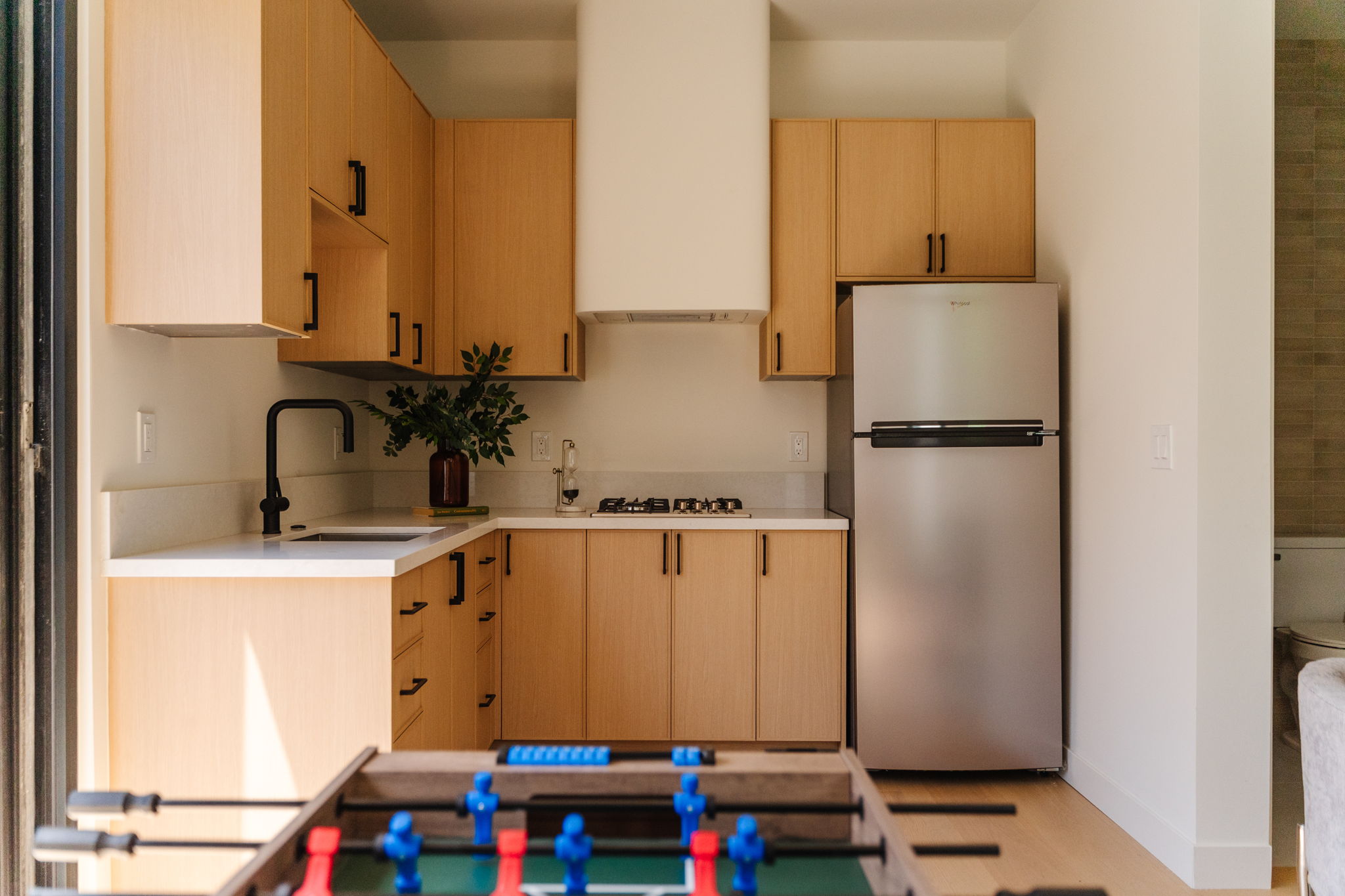 Pasadena kitchen range framed by natural wood cabinetry