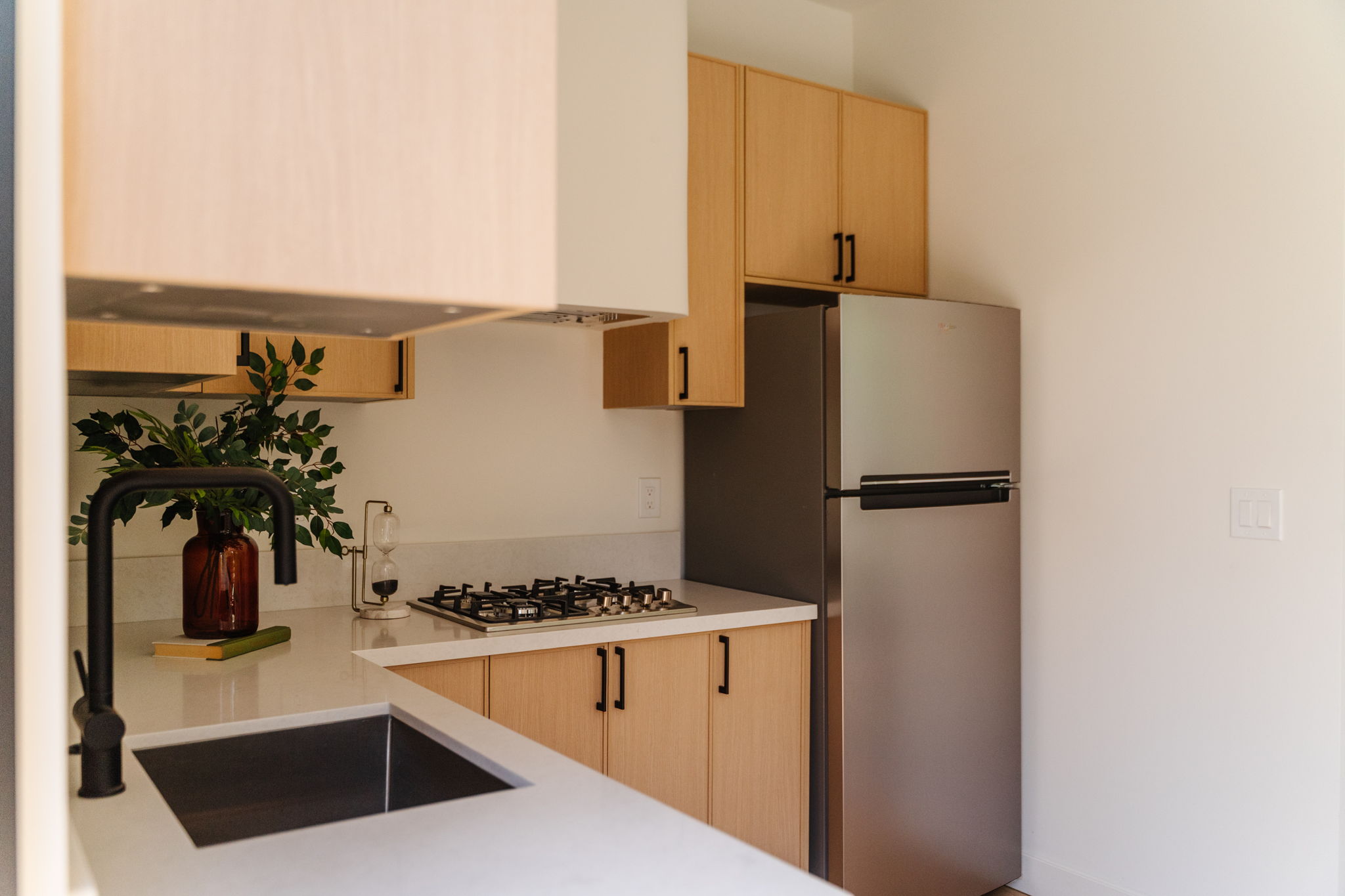 Warm modern Pasadena kitchen with light wood cabinetry and a spacious island
