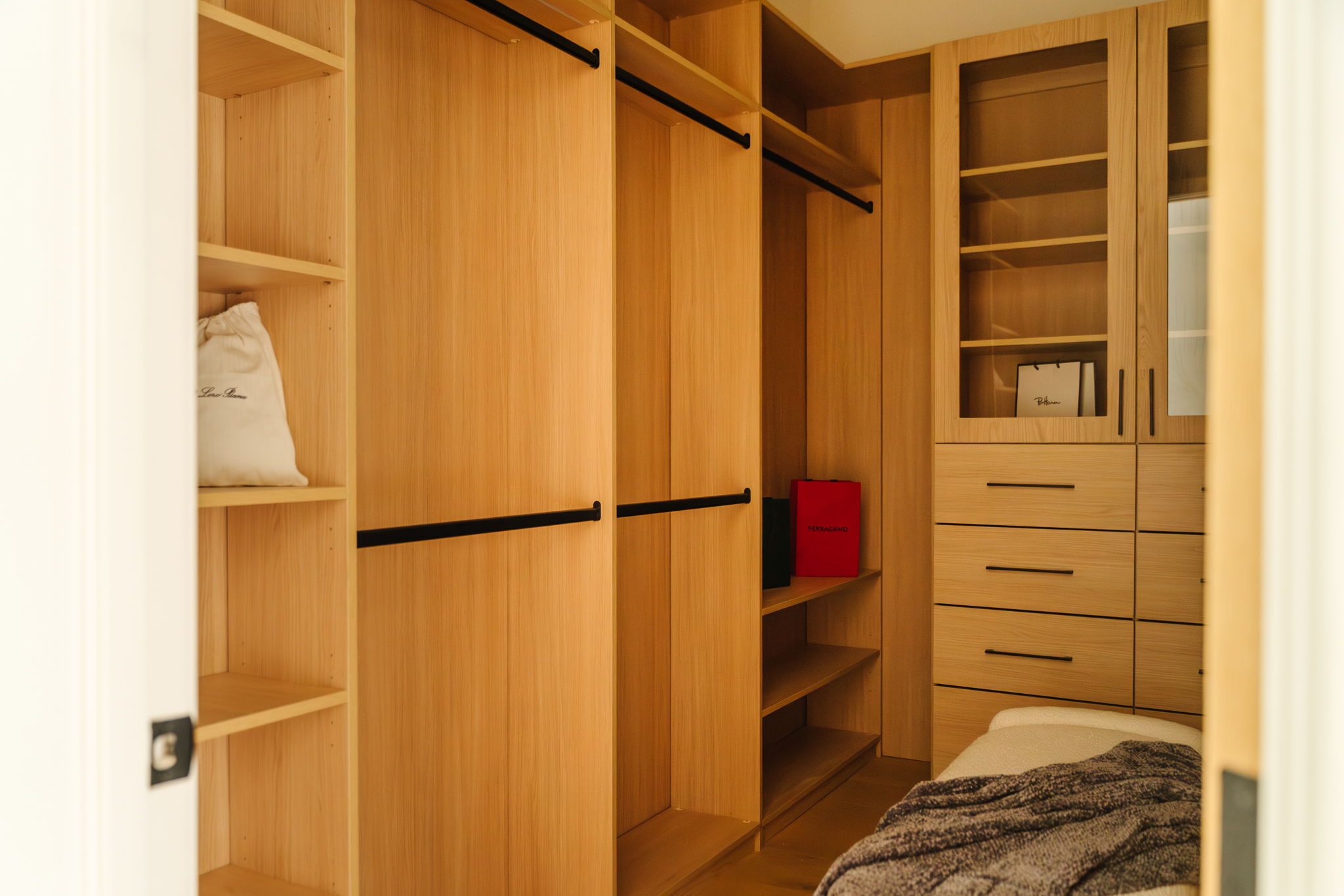 View into the Willow closet with custom light oak shelving and drawers